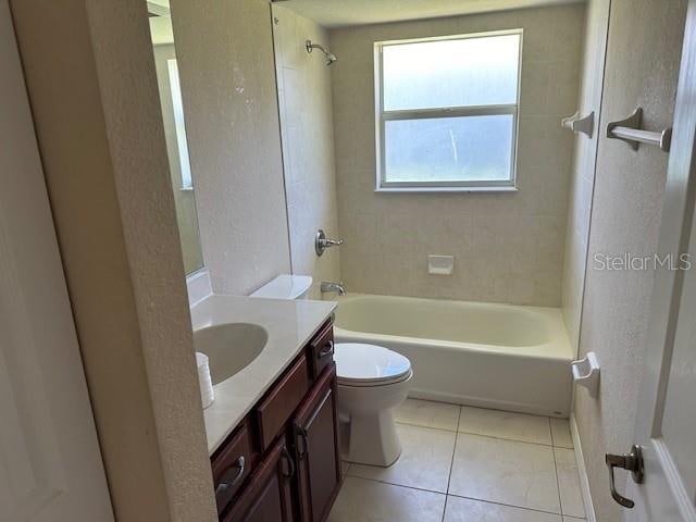 full bathroom featuring large vanity, toilet, tiled shower / bath, and tile flooring