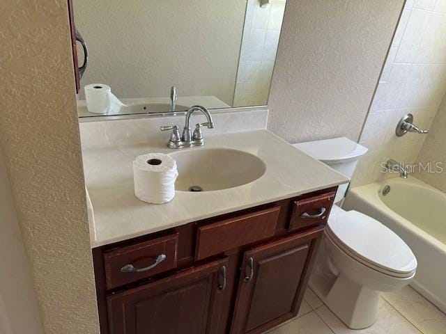 full bathroom with tiled shower / bath, toilet, tile floors, and vanity