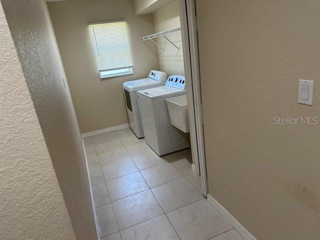 laundry area with light tile flooring and washer and clothes dryer