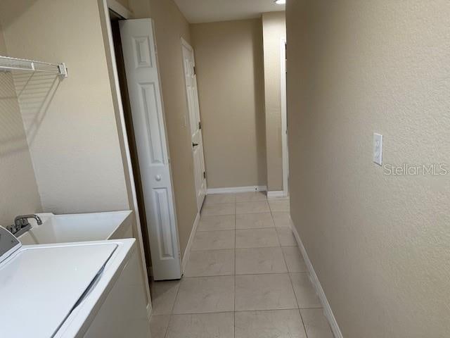 laundry area featuring light tile floors and washer / clothes dryer