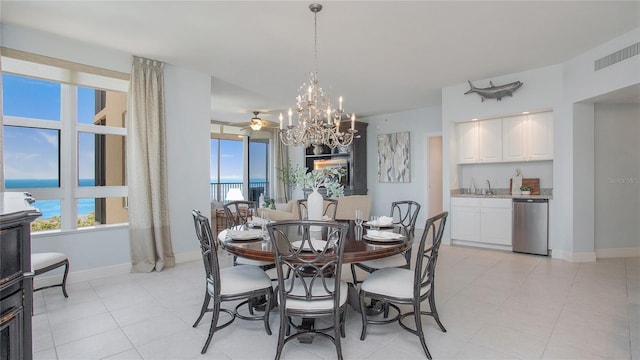 tiled dining area with sink and ceiling fan with notable chandelier