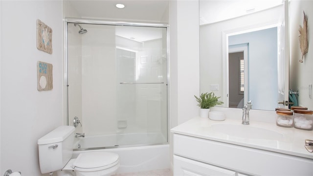 full bathroom featuring oversized vanity, toilet, and bath / shower combo with glass door