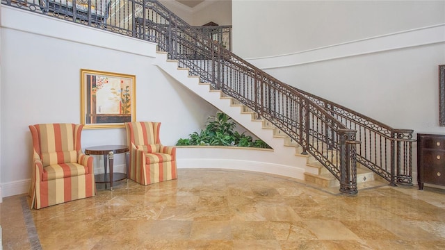 stairway with a towering ceiling and light tile floors