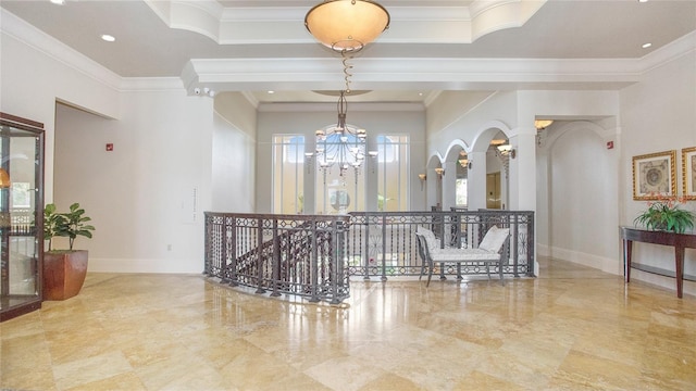 foyer with ornamental molding, light tile floors, and an inviting chandelier