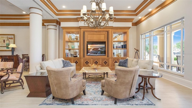 living room featuring a raised ceiling, light hardwood / wood-style floors, crown molding, and ornate columns