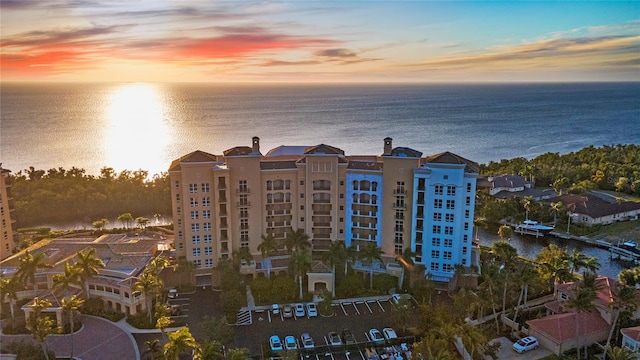 aerial view at dusk featuring a water view