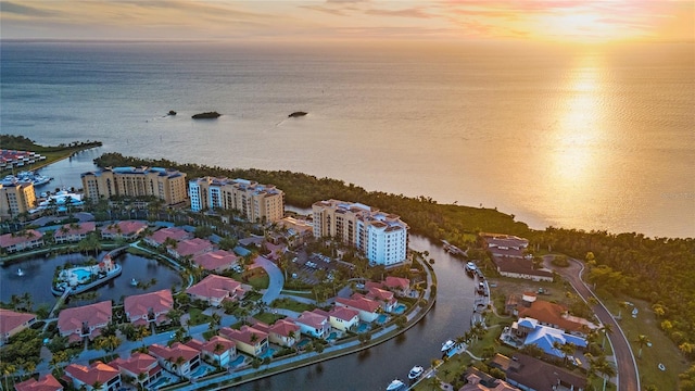 aerial view at dusk featuring a water view