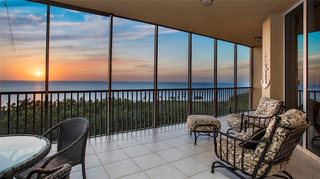 sunroom featuring a water view