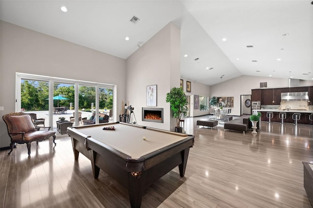 game room featuring a healthy amount of sunlight, light hardwood / wood-style flooring, high vaulted ceiling, and billiards