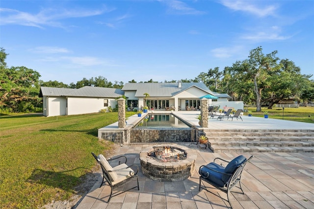 exterior space featuring a patio, a fire pit, and a lawn