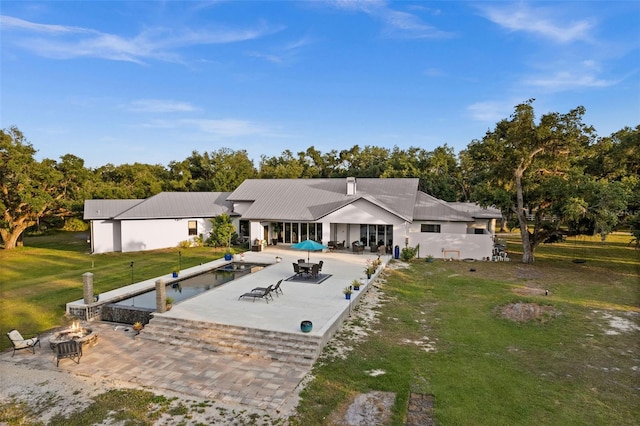 exterior space with a patio area, a fire pit, and a lawn