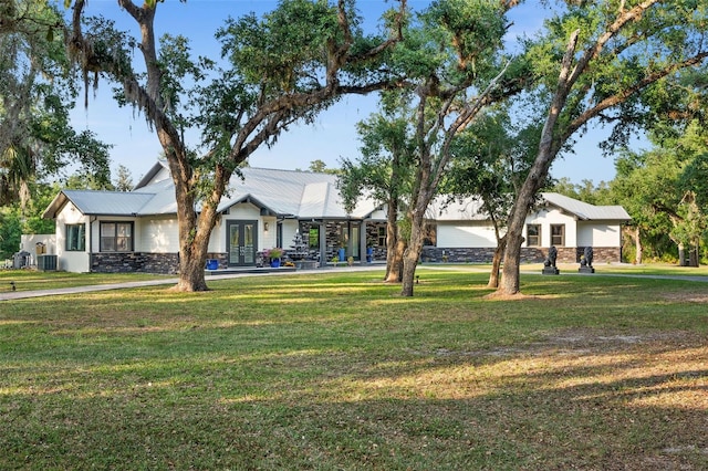 ranch-style home featuring central air condition unit and a front yard