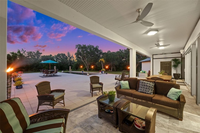 patio terrace at dusk featuring ceiling fan and outdoor lounge area