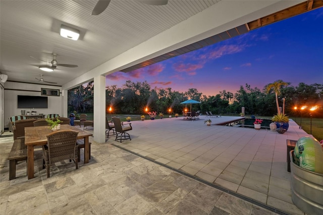 patio terrace at dusk featuring ceiling fan