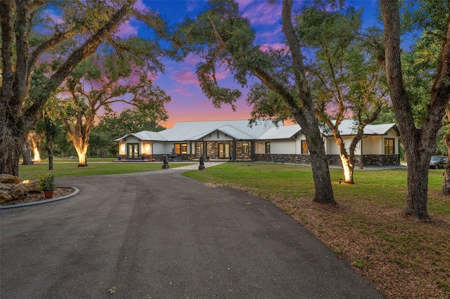 single story home with a lawn