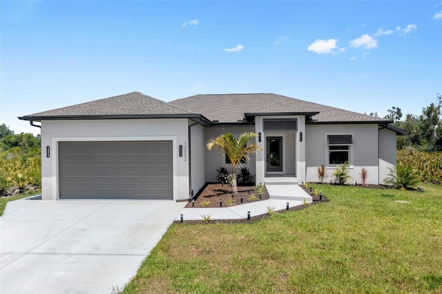 prairie-style home featuring a garage and a front lawn