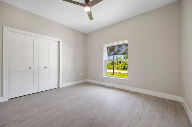 unfurnished bedroom featuring light hardwood / wood-style floors, a closet, and ceiling fan