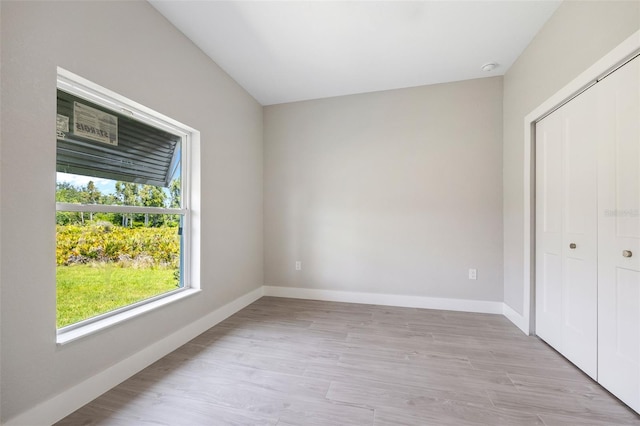 unfurnished bedroom with light hardwood / wood-style floors and a closet