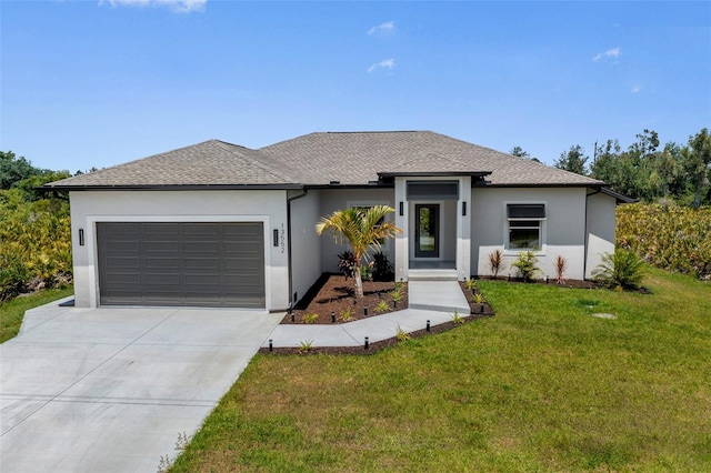 prairie-style home featuring a garage and a front lawn