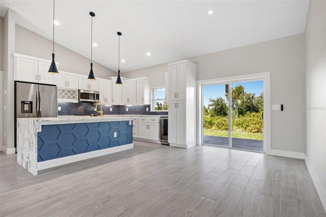 kitchen featuring white cabinets, backsplash, appliances with stainless steel finishes, and pendant lighting