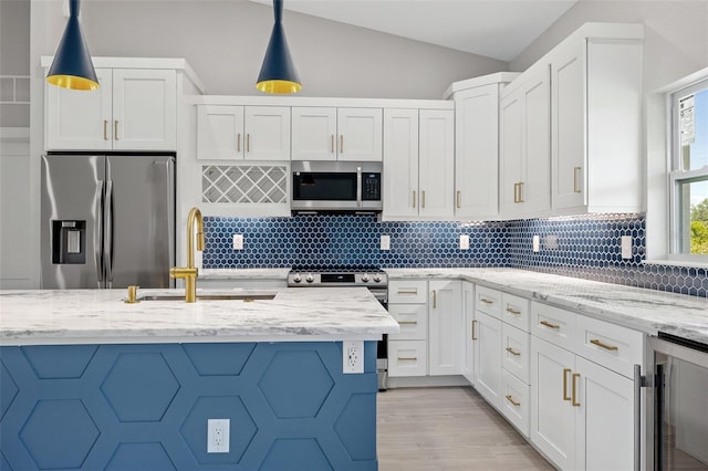 kitchen featuring appliances with stainless steel finishes, sink, decorative light fixtures, white cabinets, and light stone countertops