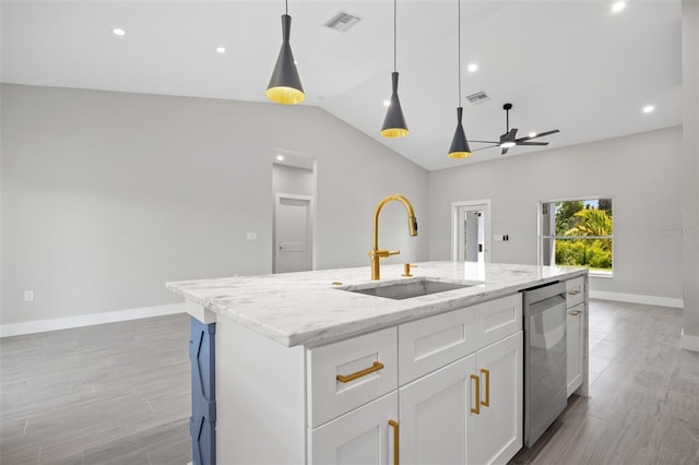 kitchen featuring dishwasher, white cabinets, sink, an island with sink, and light stone counters