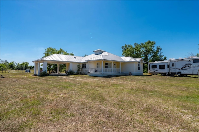 rear view of house with covered porch and a lawn