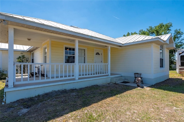 ranch-style home featuring a front lawn and covered porch