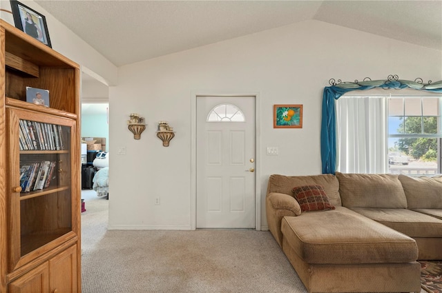 carpeted entrance foyer with vaulted ceiling