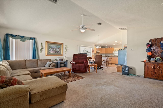 carpeted living room with vaulted ceiling, ceiling fan with notable chandelier, and a textured ceiling