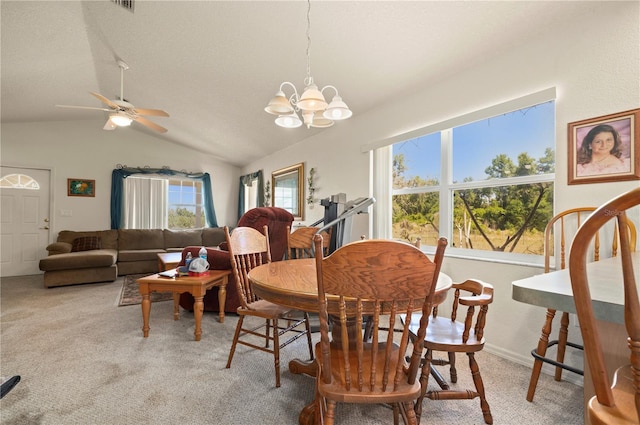 dining space featuring ceiling fan with notable chandelier, carpet floors, and lofted ceiling