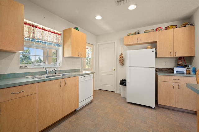 kitchen with light brown cabinetry, sink, and white appliances