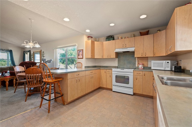 kitchen featuring a notable chandelier, white appliances, a wealth of natural light, and light brown cabinets