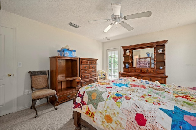 bedroom with ceiling fan, carpet, and a textured ceiling