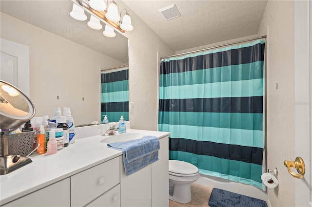 bathroom featuring toilet, tile flooring, vanity, and a textured ceiling