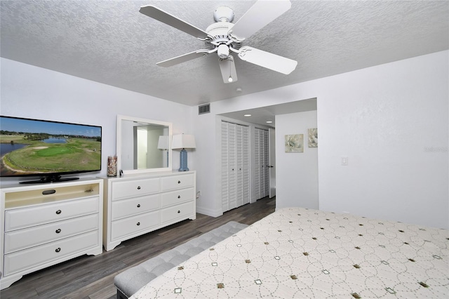 bedroom with ceiling fan, dark hardwood / wood-style floors, and a textured ceiling