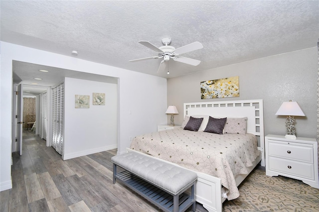 bedroom with hardwood / wood-style flooring, ceiling fan, and a textured ceiling