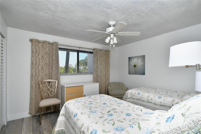 bedroom featuring ceiling fan, hardwood / wood-style flooring, and a textured ceiling