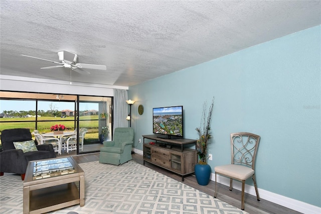 living room featuring a textured ceiling and ceiling fan