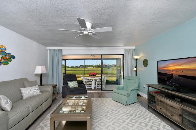 living room featuring a textured ceiling, hardwood / wood-style floors, and ceiling fan