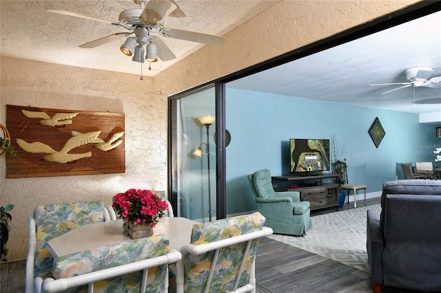 living room featuring ceiling fan and a textured ceiling