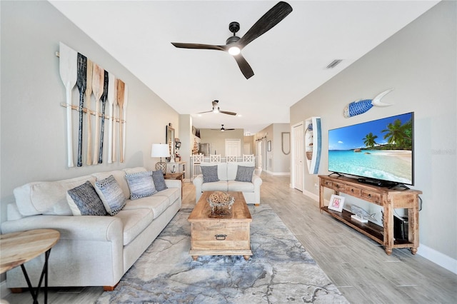 living room with light hardwood / wood-style flooring and ceiling fan