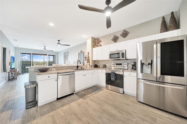 kitchen featuring light hardwood / wood-style floors, ceiling fan, kitchen peninsula, and stainless steel appliances