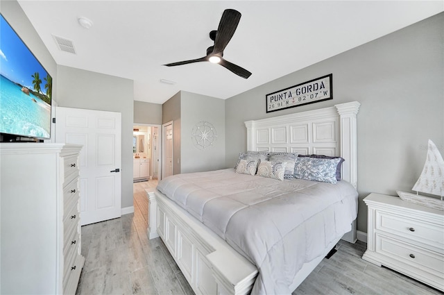 bedroom with ceiling fan, ensuite bathroom, and light wood-type flooring