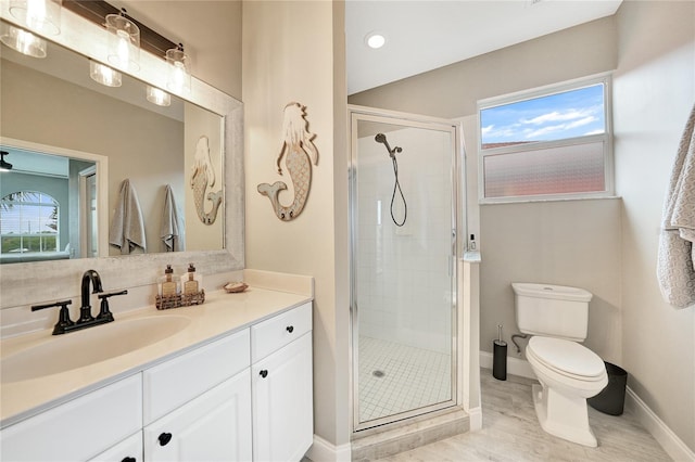 bathroom featuring a wealth of natural light, an enclosed shower, toilet, and vanity