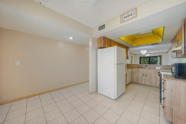 kitchen with white appliances, ceiling fan, light tile flooring, a tray ceiling, and sink