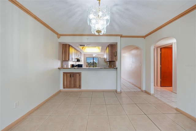 kitchen with pendant lighting, crown molding, an inviting chandelier, and light tile floors