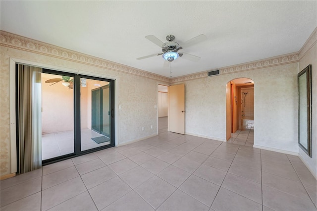 tiled empty room featuring ceiling fan