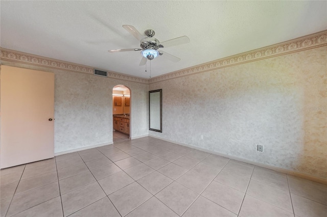 tiled empty room featuring ceiling fan and a textured ceiling