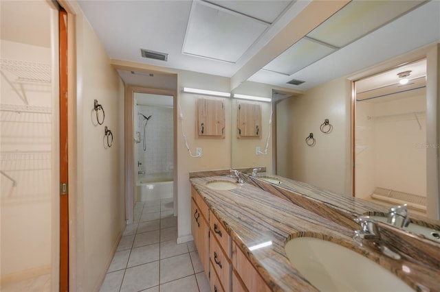 bathroom with tile flooring, tiled shower / bath, and dual vanity